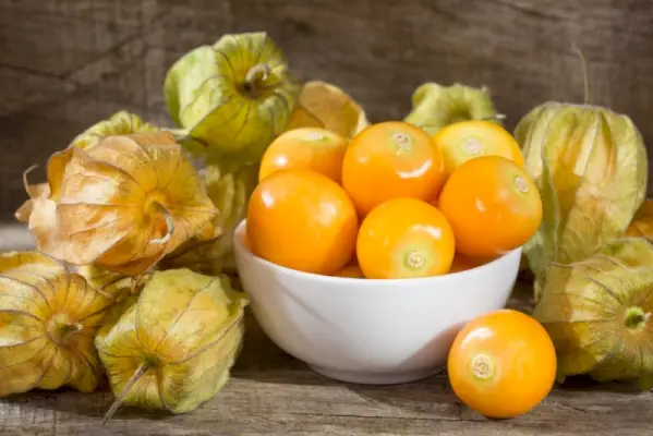 skaistas zeltainas ogas baltā bļodā