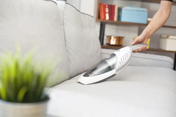 netejar el sofà amb una aspiradora de mà