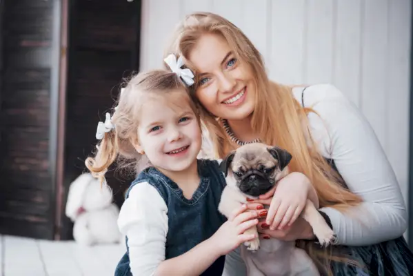 Кученце мопс с момиче и жена (семейство)