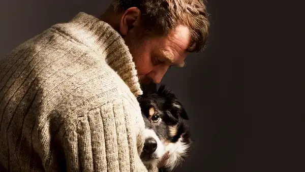 man embracing dog