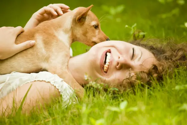 Femme heureuse allongée sur l'herbe avec son chien dans le parc