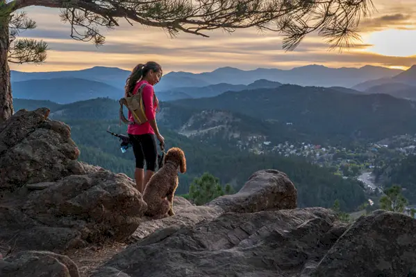 una donna sta facendo un'escursione con un cane nelle Montagne Rocciose del Colorado