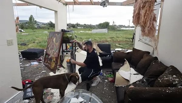 LONGMONT , CO - JUNE 5: Brandon Scott, with his dog Baxter, salvages what he can in the living room of his home that was destroyed when a tornado ripped through it at 15763 North 83rd tree in Longmont, Colorado hard on June 5, 2015. The duo along with Scott